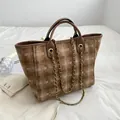 Brown woven tote bag with geometric patterns and golden chain strap on white fabric - Khaki