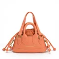 Mini borsa a tracolla corallo con coulisse e manici superiori su sfondo bianco puro - Arancione