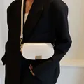 Bolso bandolera blanco con cierre dorado llevado por modelo con chaqueta negra chic - Blanco
