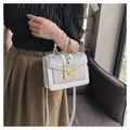 Detailed view of a white glitter shoulder bag with pearl handle and golden twist lock - White