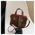 Detail of striped canvas handbag with brown leather handles and gold hardware accents - Chocolate