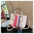 Detail einer gestreiften Mini-Tasche in Pink und Lila mit weißen Griffen und Haken - Rosenrot