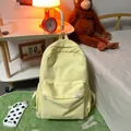 Minimalistische lichtgele canvas rugzak voor studenten met wit logo-label erop - Geel