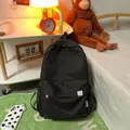 Minimalist black backpack with cute bear label and spacious multi-pocket design - Black