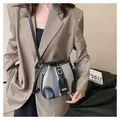 Detail of striped bucket bag with black leather straps worn with a brown blazer - Black and Blue