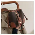 Detail of vintage tweed bucket bag with leather trim and gold hardware in hand - Chocolate