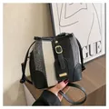 Detail shot of striped knit bucket bag with black leather trim and golden hardware - Black