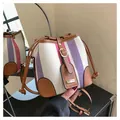 Detail view of the drawstring closure and striped canvas texture of this bucket bag - Rose Red