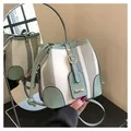 Striped contrast bucket bag in mint green woven fabric with sleek leather trim - White