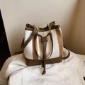 Chic bucket shoulder bag with brown and white striped fabric and leather trim - White