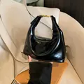 Bolso baguette negro brillante minimalista con cierre dorado y asa superior curva - Negro