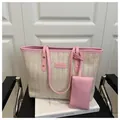 Détail de la texture tissée et bordure en cuir rose avec logo sur un grand sac cabas - Rose