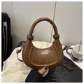 Detail showing brown crescent bag with knotted handle and white FASHION lettering text - Dark Brown