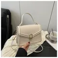 Elegant beige crossbody bag with gold oval lock and stylish envelope flap design - White