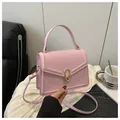 Elegant light pink crossbody bag with gold oval clasp and adjustable shoulder strap - Pink