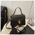 Elegant black crossbody bag with golden oval buckle and adjustable strap for women - Black