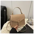 Minimalist cream crossbody bag with a gold oval twist lock and a round top handle - Khaki