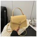 Pale yellow structured crossbody bag with gold twist lock and adjustable shoulder strap - Yellow