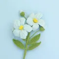 Nahaufnahme handgehäkelter Blumen mit blauen Blütenblättern und gelber Mitte auf Stielen - Blau (Afghanischer Eustoma-Zweig)