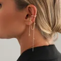 Dettaglio di un ear cuff dorato con catenine pendenti e piccole perle di metallo - Stile Nappa di Perle di Metallo (0050) / Oro