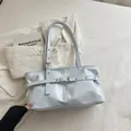 Sac à bandoulière en cuir ciré bleu clair avec boucles métalliques et détails d'œillets - Bleu
