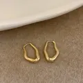 Boucles d'oreilles géométriques dorées mates avec un design en boucle ondulée - Boucles d'oreilles géométriques à vagues irrégulières (Or)
