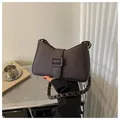 Dunkelbraune Schultertasche mit Krokodilprägung, geflochtenem Riemen und Goldteilen - Dunkelbraun