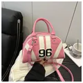 Dettaglio della borsa bowling rosa e bianca con toppa numero 96 e rivetti a stella - Rosa