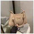 Beige shoulder bag with metallic bow and knotted rope strap in minimalist style - Khaki