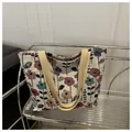 Detailaufnahme der Blumenmuster-Canvas-Tasche mit gelben Tragegriffen auf einem Regal - Stil 2