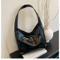 Macro shot of glossy black patent leather shoulder bag with sleek rectangular label detail - Black