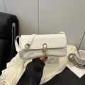 Weiße Baguette-Tasche aus Kunstleder mit goldenem Ovalverschluss und Trageriemen - Weiß