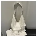 Detailopname van een witte halve maan schoudertas met lange franjes en brede riem - Wit