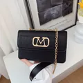 Bolso bandolera negro con relieve de cocodrilo, logo M dorado y correa de cadena - Negro