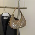 Brown half-moon underarm bag with silver studs on matte faux leather hanging on rack - Khaki
