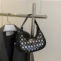 Fashionable black crescent shoulder bag with silver studs and polished finish - Black