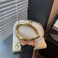 Chic white oval pillow bag with luxury gold metal handle and sleek snake chain strap - White