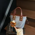 Blue denim and brown leather tote bag with monster charm on wooden stairs - With Pendant / Blue