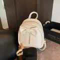 Mini cream backpack for women featuring a large bow detail and adjustable straps - White