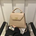 Elegante bolso de mano trapezoidal beige con cierre dorado y correa de hombro - Caqui