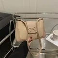 Minimalist beige saddle bag featuring woven texture and a gold bow buckle detail - Khaki