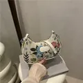 Borsa a mezzaluna in tessuto floreale crema con tracolla in pelle e catena argento - Bianco