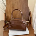 Borsa a cuscino in pelle lucida marrone scuro con manici e dettagli dorati - Marrone Scuro