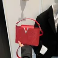 Borsa a mano rossa con paillettes e logo V argentato, ideale per look da ufficio chic - Rosso