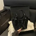 Secchiello nero chic in pelle plissettata con logo dorato su sfondo scatola regalo - Nero