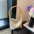 Elegante borsa a mano in seta champagne con ricami e dettaglio manico in perline - Schermo Beige
