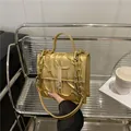 Golden tote bag with 3D thorn texture and chunky chain strap on a modern shelf - Gold