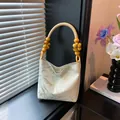 Borsa a mano ricamata color crema con jacquard blu e manico intrecciato con perline - Foglia Beige