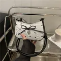 Borsa a spalla in seersucker bianca con fiocchi neri e ciondolo a cuore metallico - Bianco