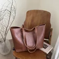 Borsa tote in pelle marrone vintage con scritte dorate su sedia in legno per ufficio - Cuoio